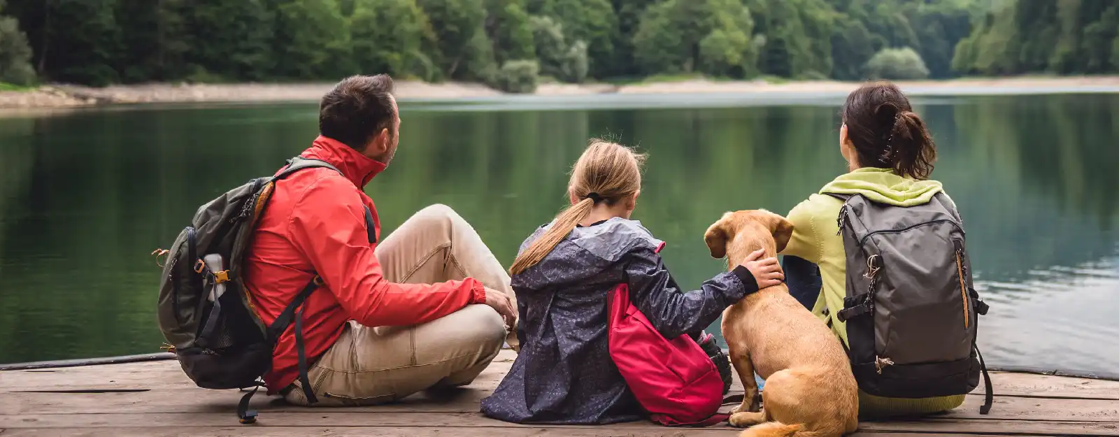 Family and dog sitting on dock